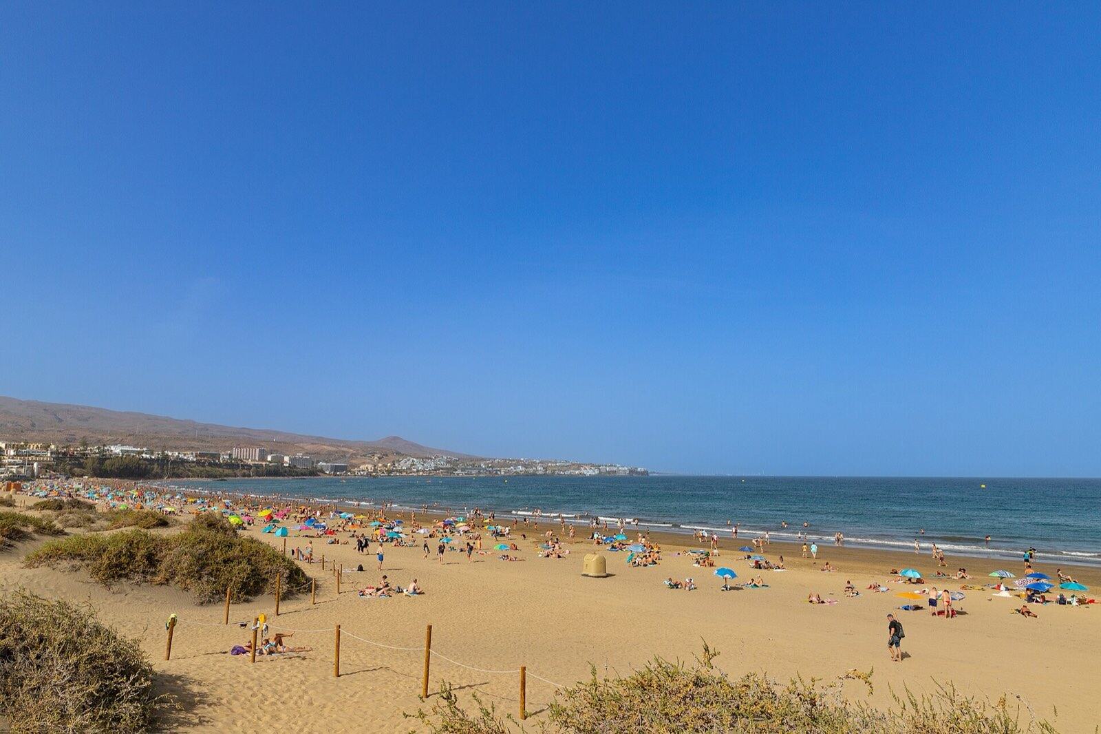 Solfylt strand ved Maspalomas-dynene på Gran Canaria med turkist hav