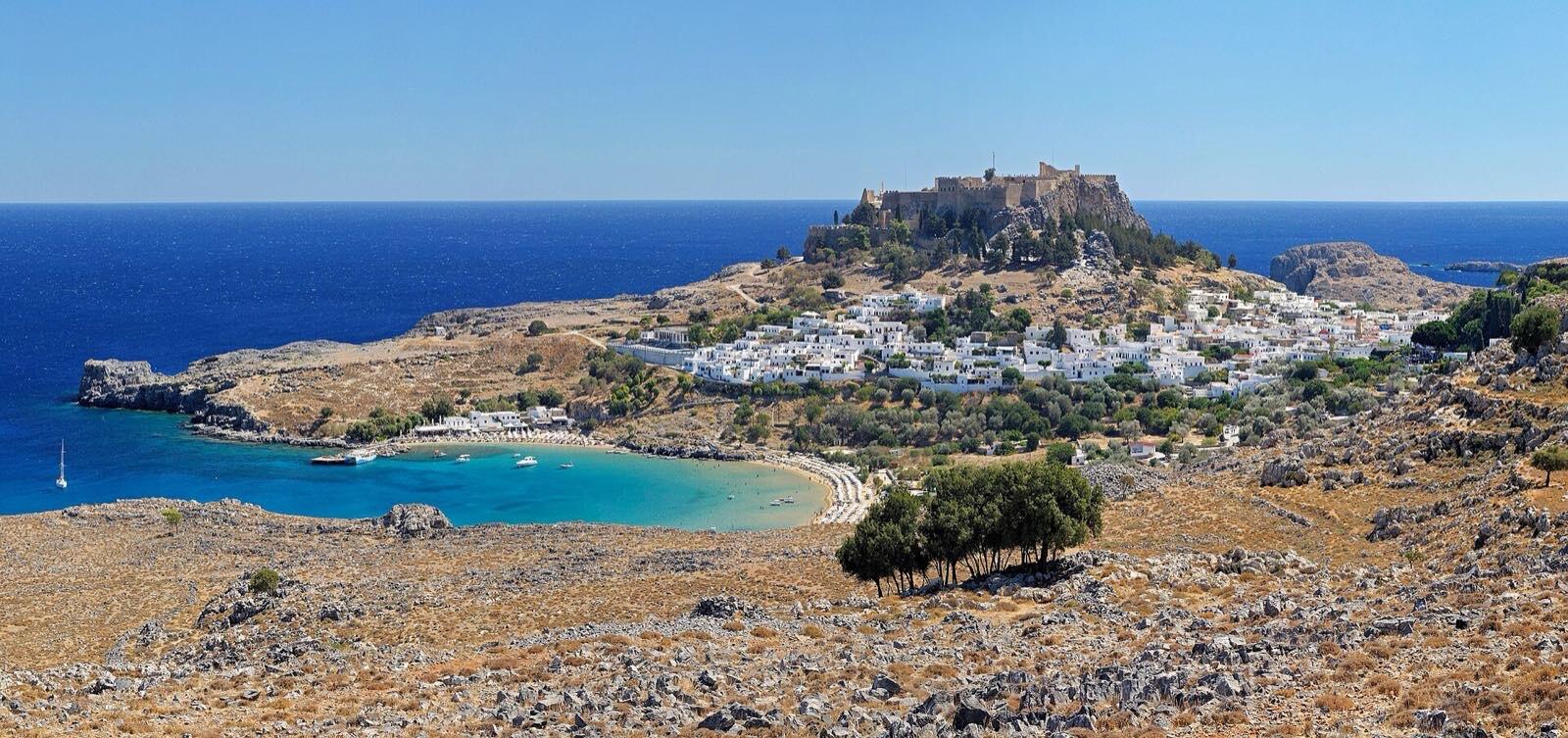 Panorama av Lindos med akropolis, hvit by og turkis bukt